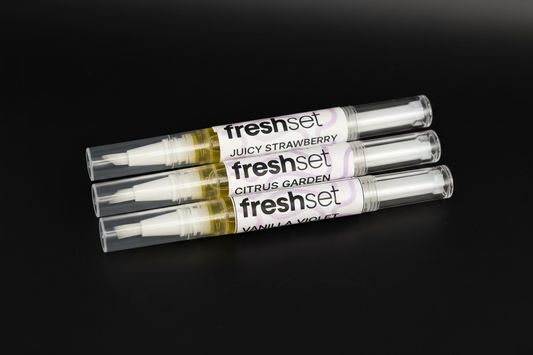 Three cuticle oil pens on black background