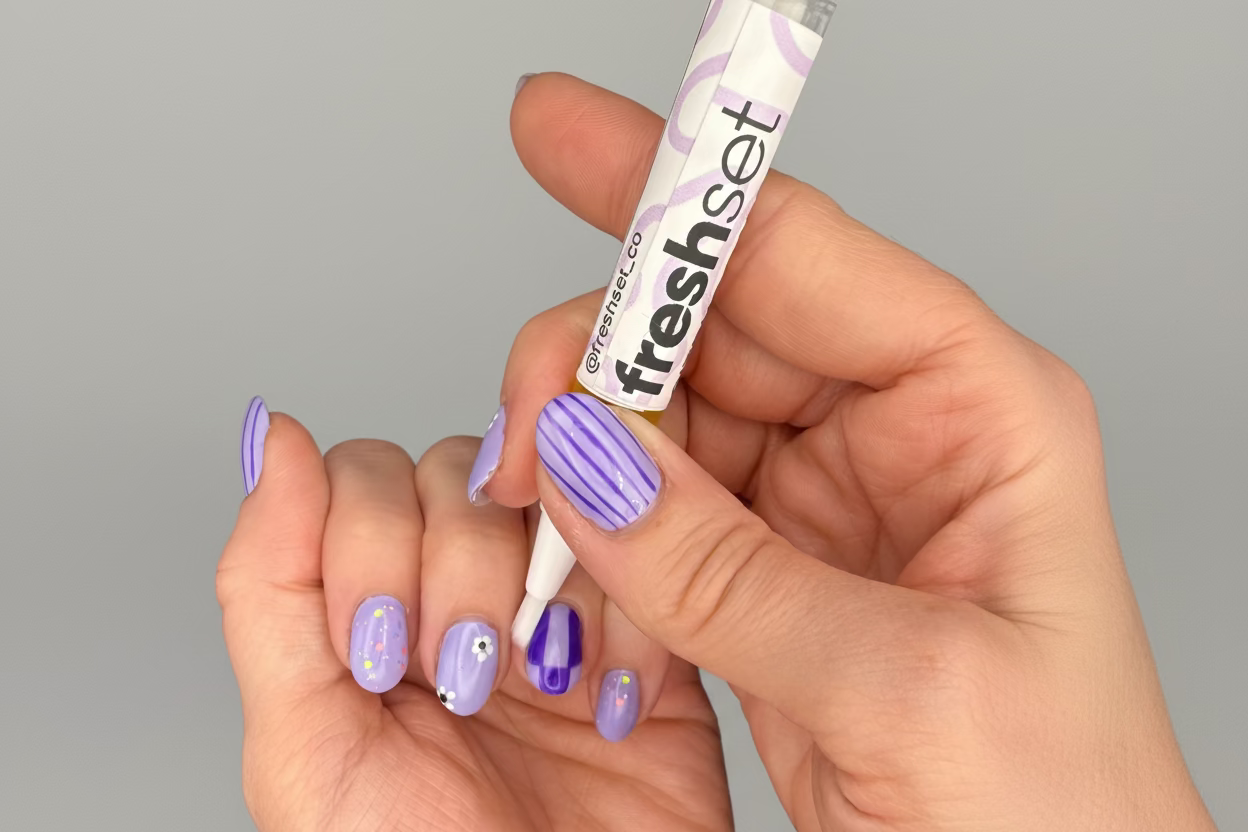 Hands applying cuticle oil