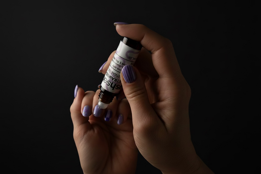 Hand holding a small bottle of cuticle oil