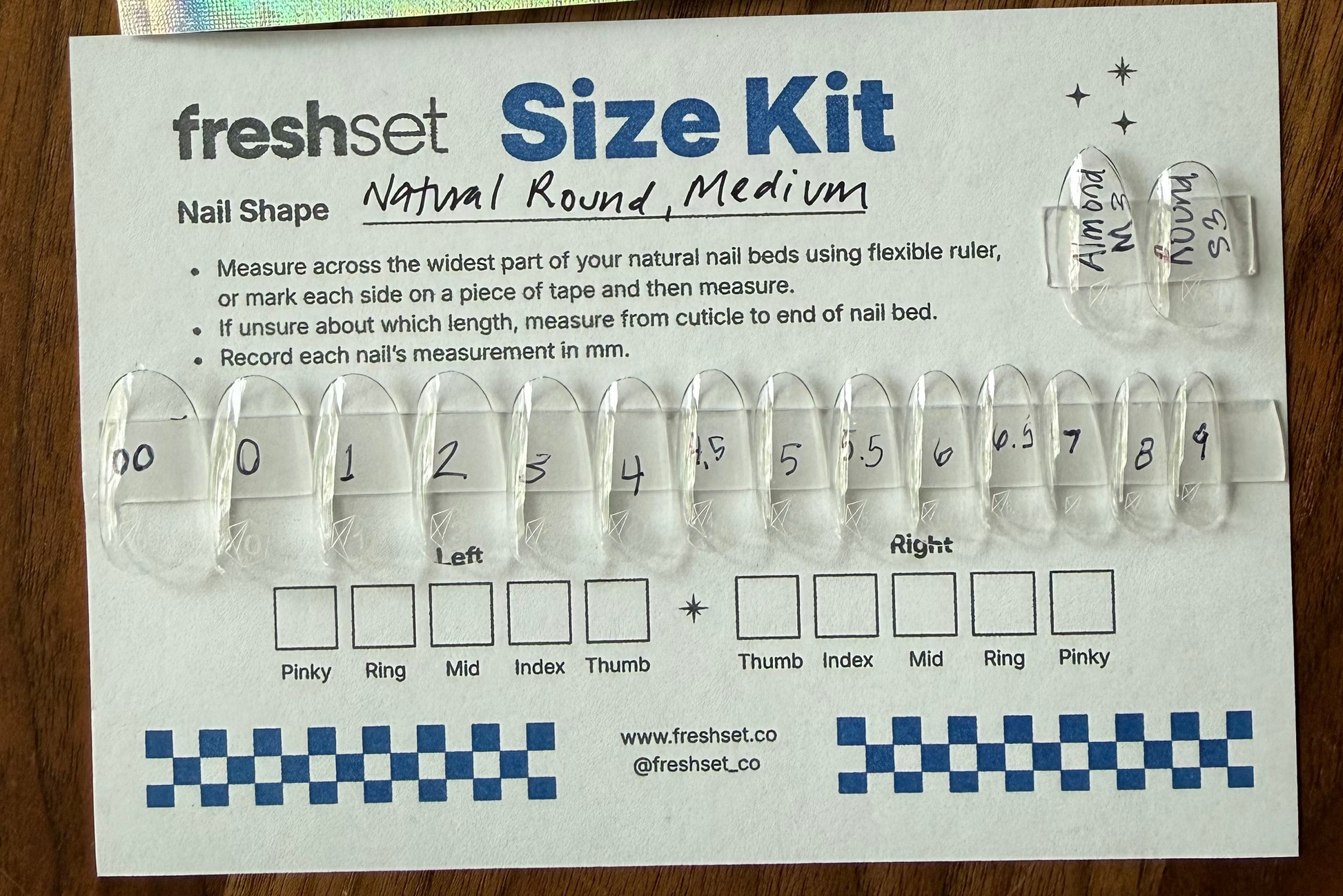 Nail shape size kit with nail samples and measurement chart on a wooden surface