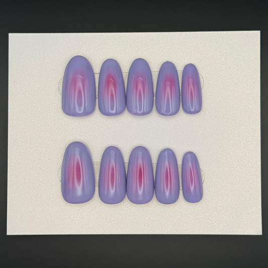Purple and pink press on nails on a white card and black background