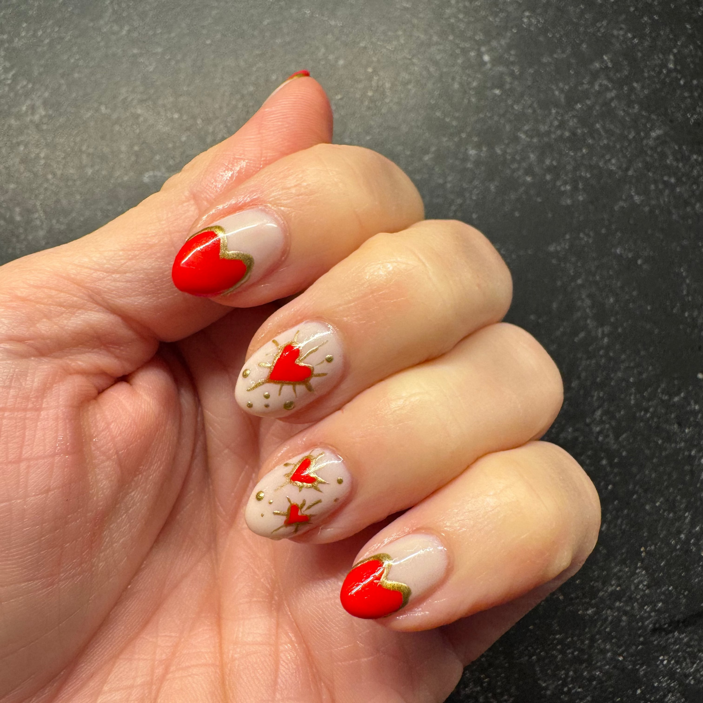 Hand with red hearts and gold paint details