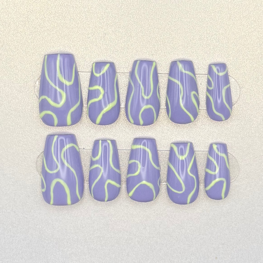Press on nails painted with lavender purple and light green swirls