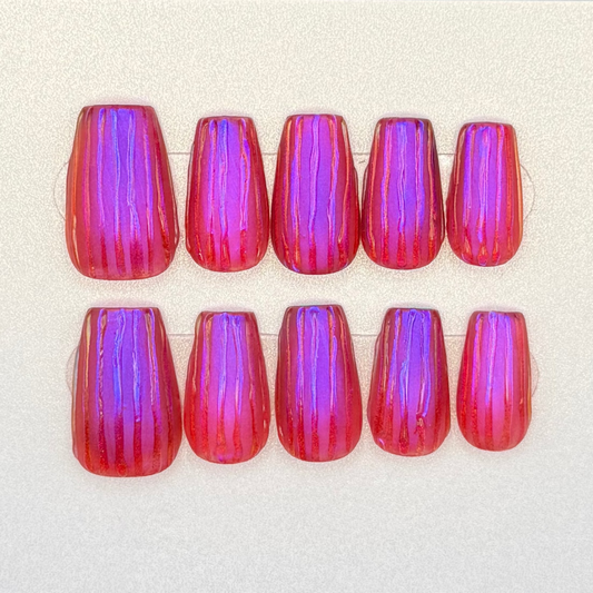 Painted press on nails with iridescent pink nails with purple chrome and a textured 3D stripe